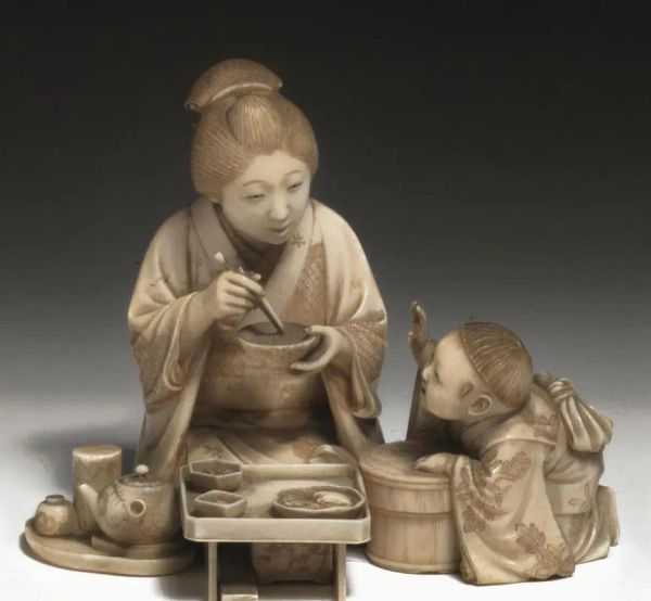 Okimono, Giappone inizi sec. XX, in avorio, raffigurante figura femminile con bambino e tavolino imbandito, cm 10,5