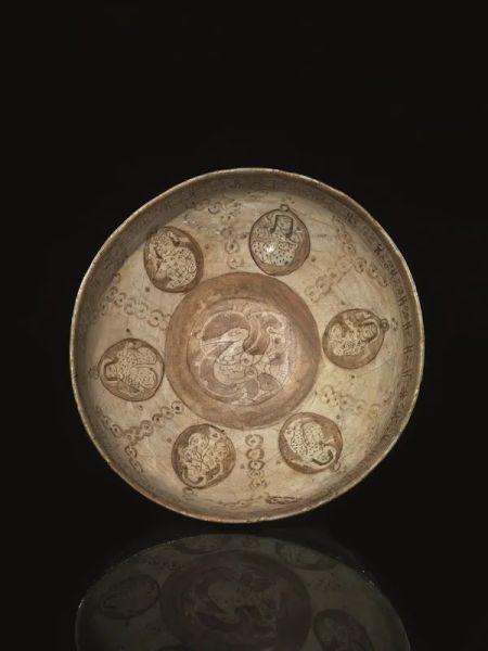  Coppa Nishapur, Iran XI sec  in maiolica decorata con volatile al centro e figure entro riserve ovali separate da decorazioni geometriche, diam cm 19,7  restaurata 