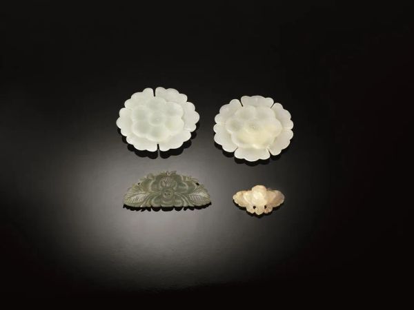  Quattro bottoni, Cina sec. XIX-XX,  in giada, due intagliati come due corolle di fori e due a forma di piccola farfalla il piÃ¹ grade diam.. cm 3(4) 