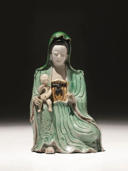  Figura, Cina sec. XVII,  raffigurante guanyin in porcellana invetriata, in posizione assisa e reggente un bambino, alt. cm 20,3  difetti 