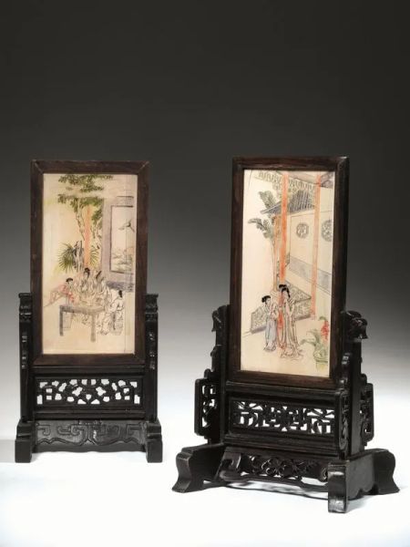 Due paraventi da tavolo, Cina dinastia Qing (1644-1911),  in avorio decorato a figure, uno con iscrizione, montati su basi differenti in legno intagliato, cm 20x10 le placche, alt. cm 16,5,  danni su uno dei pannelli 