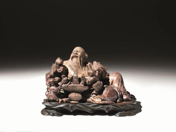  Scultura Cina sec. XIX-XX,  in pietra saponaria raffigurante budda ridente    sdraiato, ai suoi piedi due bambini e un cesto di frutti , cm 20x11, su base in legno alt. cm 2,5