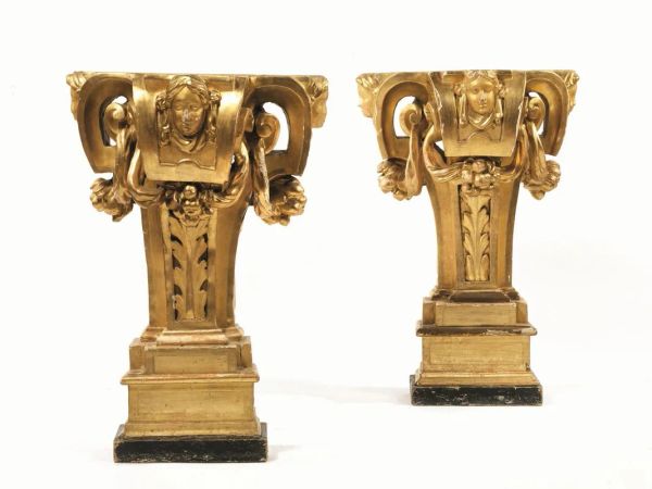  Coppia di mensoloni, Toscana, inizi sec. XVIII,  in legno scolpito e dorato modellati a volute con protomi femminili su base modanata, cm 61x34x88,  alcuni danni 