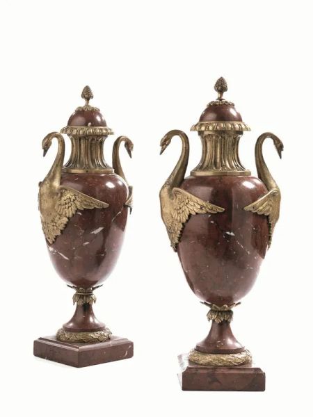  Coppia di vasi,  in marmo rosso e metallo dorato, collo baccellato,   anse configurate a cigno, poggianti su base quadrata, alt. cm 45 (2)