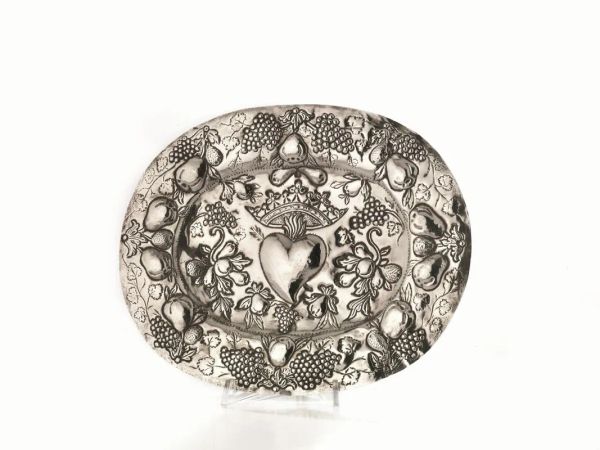 Vassoietto, sec. XIX, di forma ovale in argento sbalzato a frutti, al centro il Sacro Cuore di Ges&ugrave;, cm 29x23, g 190
