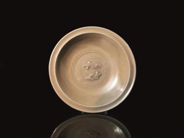  Coppa, Cina probabilmente di epoca Yuan   (1260-1368) , in porcellana cÃ©ladon color biscotto con due carpe in rilevo nel cavetto, diam. cm 21