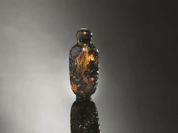  Snuff-bottle, Cina  inizi sec. XX,  in ambra intagliata, a forma di vaso squadrato e decorata a rami di pesco in fiore, alt. cm 7 