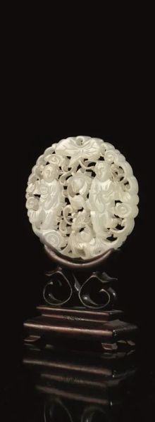 Placca circolare, Cina inizi sec. XX, in giada traforata, raffigurante due personaggi in tralci fioriti, diam. cm 5.8, su base in legno
