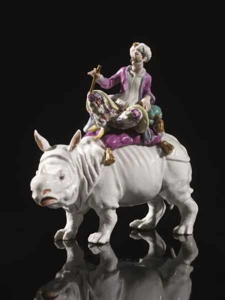  Statuina, Meissen, sec. XX,  in porcellana bianca modellata come un rinoceronte cavalcato da una figura di turco in policromia, alt. cm 22,5   