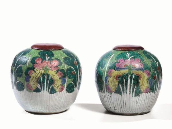  Coppia di potiches, Cina, inizi sec. XX,  in porcellana decorata a motivi floreali, coperchi in legno, alt. cm 20 (2)