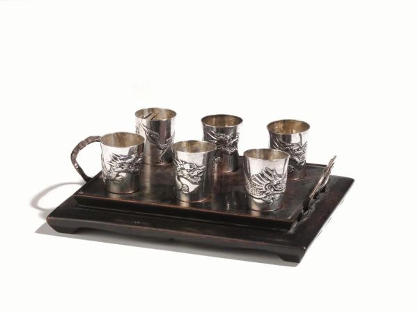  Sei bicchieri con vassoietto, Giappone inizi sec. XX,  in argento, cesellati con motivo di dragoni, gr. 105, alt. cm 3,5, vassoietto cm 17,5x13,5 (7)