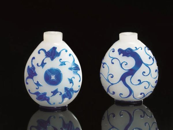  Due snuff-bottles, Cina dinasia Qing (1644-1911),  in vetro incamiciato bianco e blu, una decorata a motivo di draghi, laltra da pipistrelli e simboli di buon auspicio, alt. cm 10,7; cm 10(2)