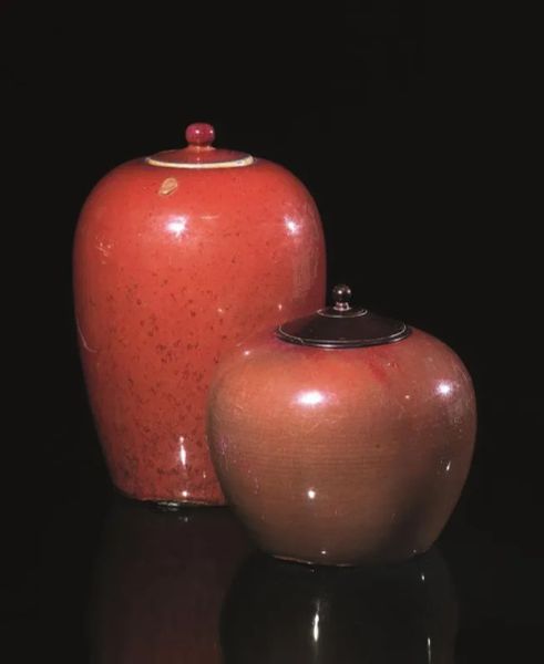  Due vasi sangue di bue con coperchio, Cina sec. XIX,  un coperchio in legno alt. cm 33, cm 21(2)