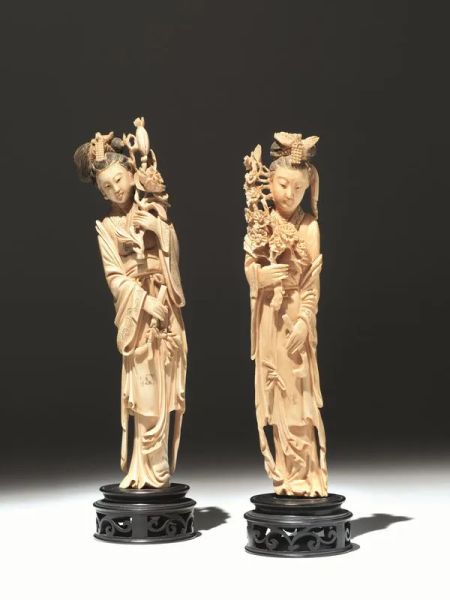  Due sculture, Cina sec. XIX-XX,  in avorio ciascuna raffigurante Guanyn stante, elegantemente vestita, con un&rsquo;elaborata acconciatura e reggente un ramo fiorito, alt. cm 25, su base in legno alt. cm 4,  lievi mancanze  (4) 