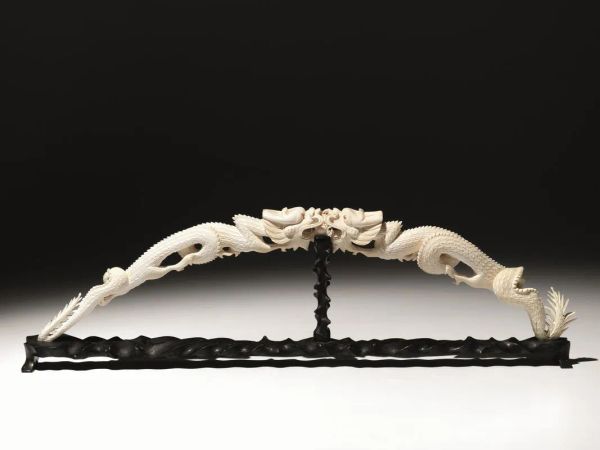  Intaglio Cina sec. XX,  in avorio raffigurante coppia di draghi che si affrontano, lung. cm 62, su base in legno. 