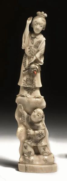 Okimono, Giappone sec. XIX, in avorio, raffigurante figura maschile sormontata da figura femminile reggente fiore con pistillo in corallo, alt. cm 20,3
