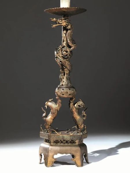  Candelabro, Cina sec. XIX-XX,  in bronzo con base a plinto decorata con due cani di Pho posti lateralmente sulla base a sorreggere lo stelo con un drago che si arrampica sullo stelo, montato ad elettricitÃ  alt. cm 54