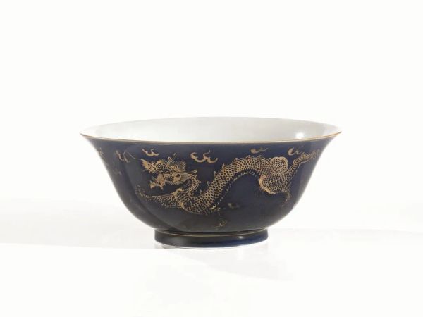 Ciotola, Cina sec. XVIII-XIX, in porcellana, a fondo blue decoro a draghi dorati, reca marchio Qianlong, diam. cm 19.4, piccolo chip al bordo