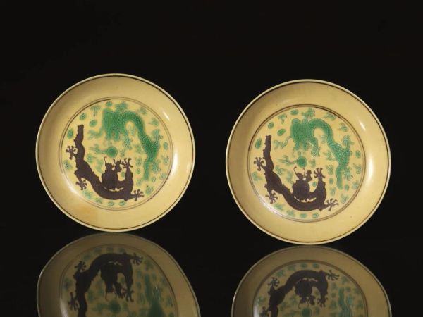  Coppia di piccoli piatti, Cina sec. XIX,  in porcellana dal fondo giallo decorati con draghi contrapposti, recano marchio sul fondo periodo Guangxu (1875-1908), diam. cm 13 (2) 