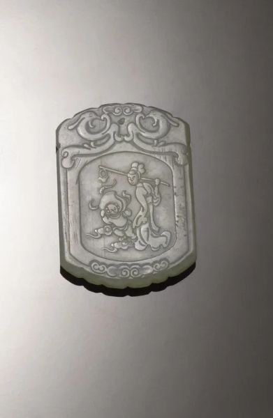 Placchetta, Cina dine dinastia Qing , in giada celadon, un lato con inscrizione e lÃ¢â‚¬â„¢altro con personaggi e teste di fenici, cm 5,4x3,6