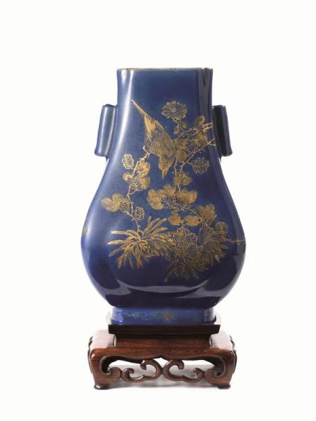 Vaso Cina sec. XVIII - XIX, di forma arcaica, in porcellana a fondo blu con decori di volatili tra rami fioriti in oro, reca marchio Qianlong, alt. cm 30, poggiante su base in legno