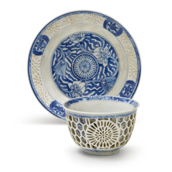



A BLUE AND WHITE PORCELAIN RETICULATED TEACUP AND SAUCER, CHINA, QING DYNASTY, 19TH CENTURY