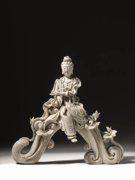  Scultura Cina sec. XX,  in porcellana bianca Dehua raffigurante Bodhisattva assisa su di un'onda avvolta da fiori di loto e draghi, alt. cm 37,5