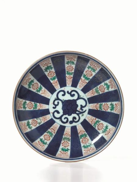  Piatto Giappone sec XVIII-XIX,  in porcellana Kutani, centrato da un motivo floreale e con decoro a raggi, diam cm 28
