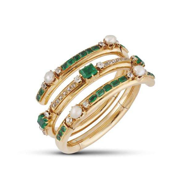 SPIRAL-SHAPED NATURAL PEARL AND COLOMBIAN EMERALD BANGLE IN 18KT YELLOW GOLD