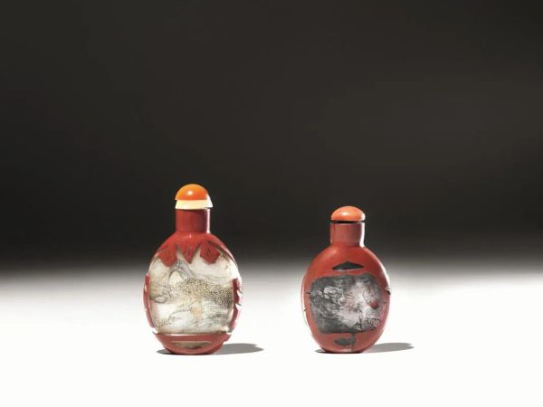 Due snuff bottles, Cina sec. XIX-XX,  in vetro dipinto dall&rsquo;interno e ricoperto parzialmente all&rsquo;esterno da una superfice laccata rossa, alt. cm 7,5; alt. cm 8 (2) 