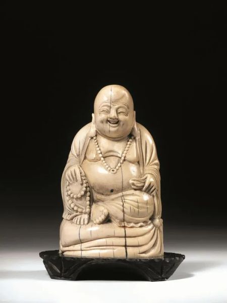  Buddha, Cina sec. XIX, in avorio , reggente una collana, su base in legno, alt. cm 13,2