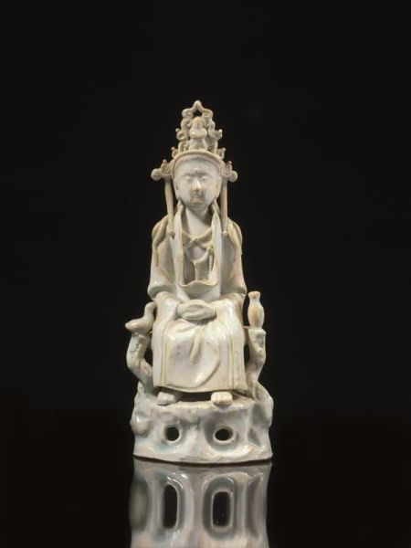  Sculturina Cina sec. XIX,  in porcellana  con invetriatura Celadon, raffigurante Guanyin assisa su un trono alt. cm 21                                       