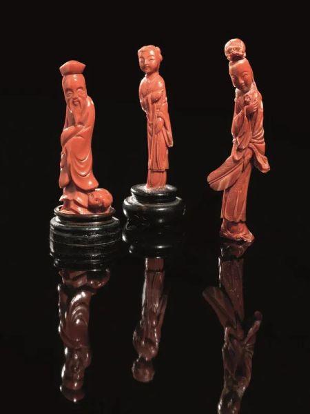  Tre sculture, Cina sec. XX , in corallo rosso, raffi guranti una un saggio, e le altre due delle Guanyin, alt. cm 13; cm 9,6; cm
