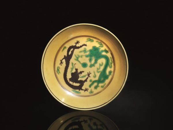  Piattino, Cina marchio e periodo Guanxu (1875-1908),  in porcellana gialla, decorate al fronte da draghi e da gru con nuvole al retro, diam cm 14,2