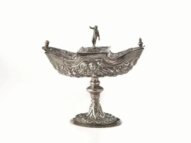 Navicella porta incenso, sec. XVIII, in argento sbalzato a festoni di foglie e volute, fusto a balaustro, coperchio a due sportellini, al centro figura a tutto tondo, lievi danni e restauri, alt.cm 17, g 270&nbsp;  - Auction Silver and Coins - II - Pandolfini Casa d'Aste